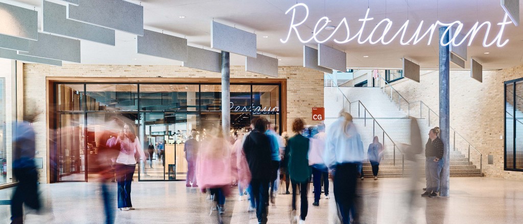 Eingang zum Betriebsrestaurant am W&W-Campus mit verschwommenen Menschen