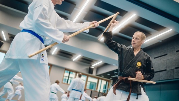 2-mänliche-Mitarbeiter-bei-Karate-Sportübung-mit-Stöcken