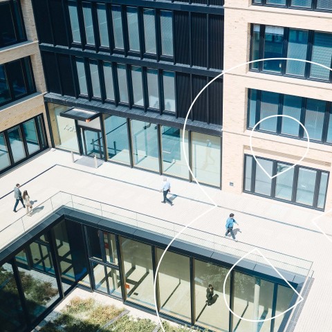 Blick auf Menschen zwischen den Campus-Gebäuden aus der Vogelperspektive