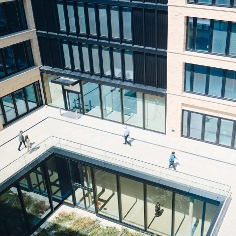 Blick auf Menschen zwischen den Campus-Gebäuden aus der Vogelperspektive