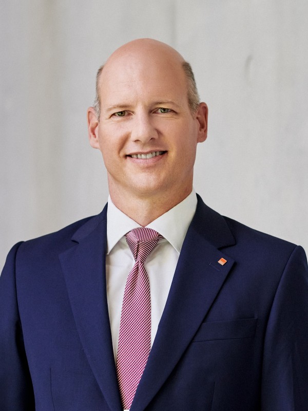 Vorstandsvorsitzender steht vor einer grauen Wand