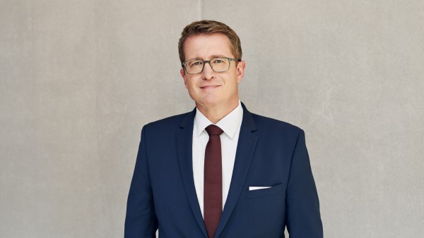 Geschäftsfeldleiter Bernd Hertweck steht vor einer grauen Betonwand
