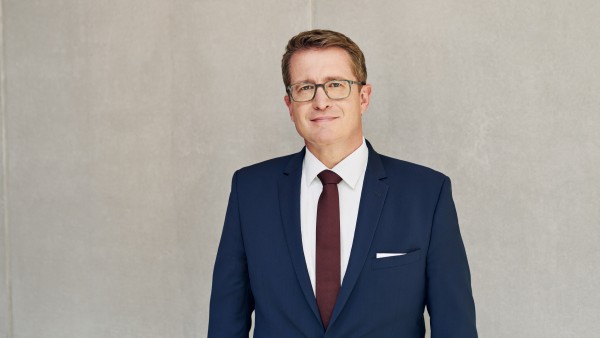Geschäftsfeldleiter Bernd Hertweck steht vor einer grauen Betonwand