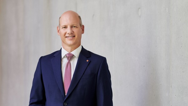 Vorstandsvorsitzender steht vor einer grauen Wand