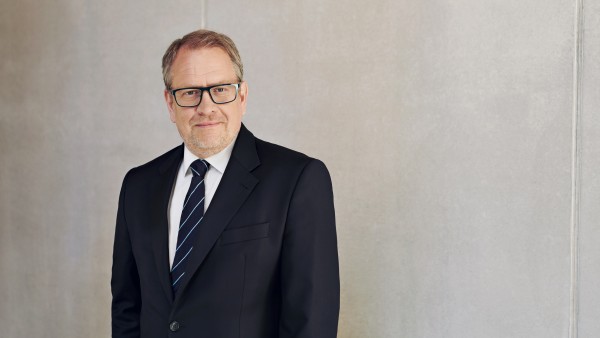 Chief Operating Officer Jens Wieland steht vor einer grauen Betonwand