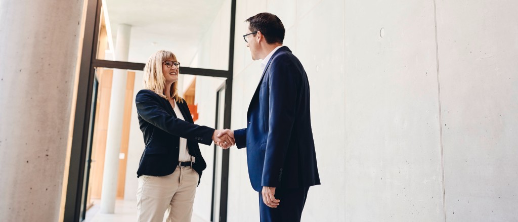 Eine Frau schüttelt nach einer männlichen Personaler die Hand