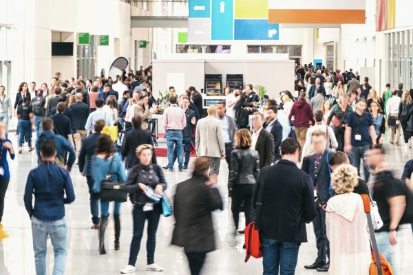 Eine Menschenmenge die über die Gänge einer Messe läut