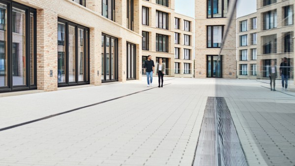 Junger Mann und Frau laufen im Campus auf der Plaza entlang