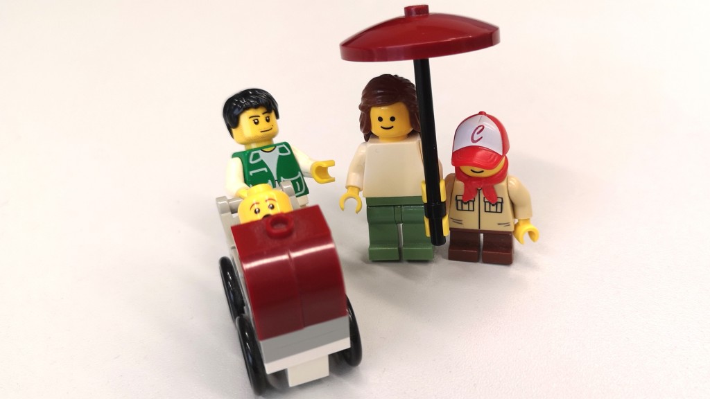 Legofamilie unter beschützendem Regenschirm