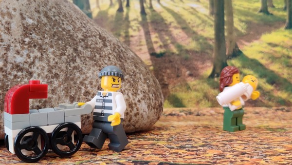 Legomännchen mit Kinderwagen stehen im Wald