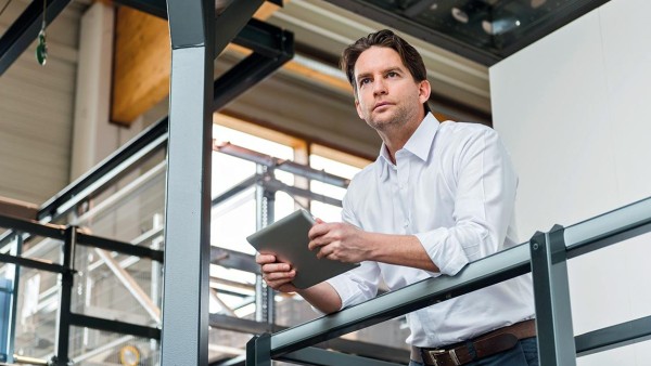 Mann mit Ipad an einer Brüstung