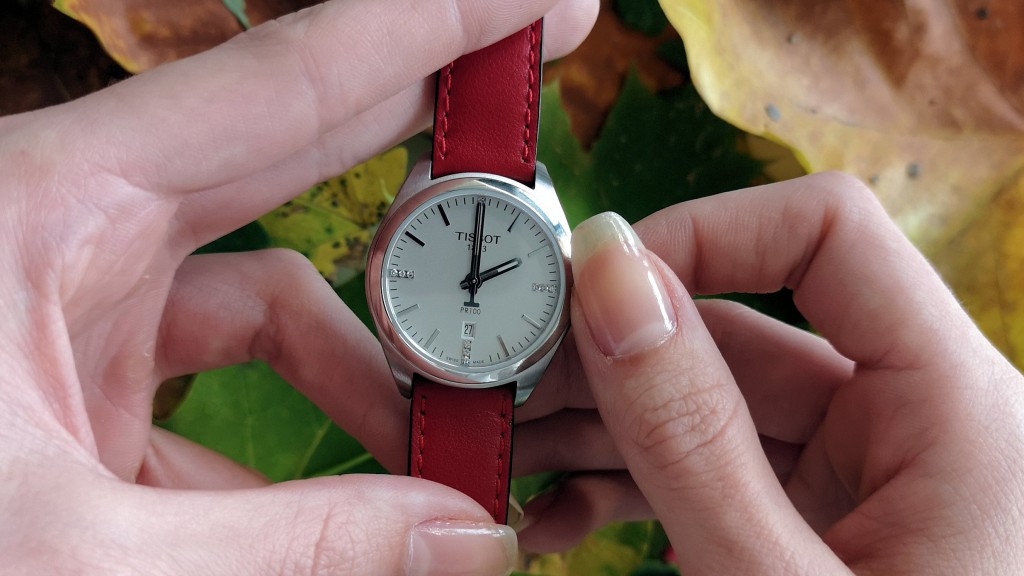Hand hält Uhr und stellt Zeit um