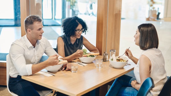 Drei junge Mitarbeiter essen gemeinam zu Mittag