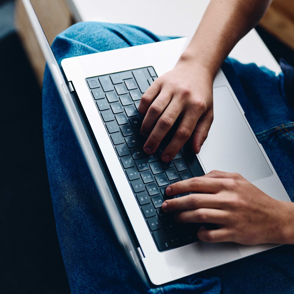 Hände eines jungen Manns tippen auf Lapotoptastatur