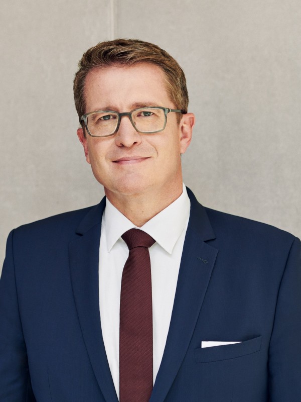 Geschäftsfeldleiter Bernd Hertweck steht vor einer grauen Betonwand