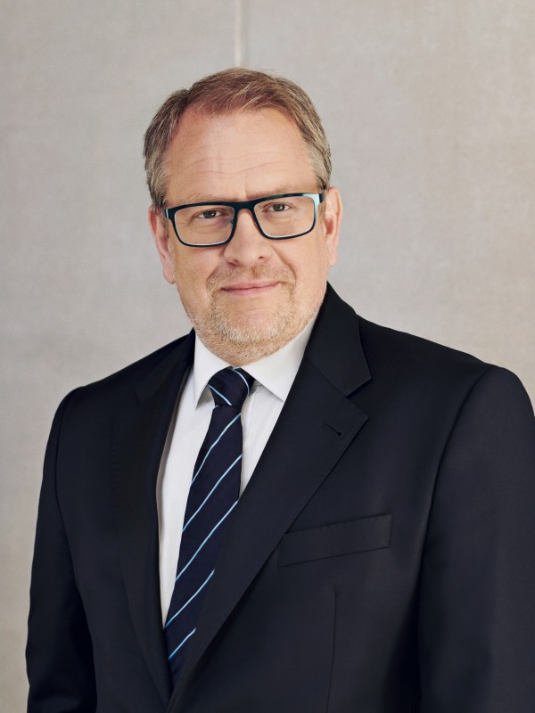 Chief Operating Officer Jens Wieland steht vor einer grauen Betonwand
